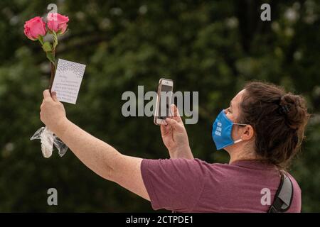 Washington, États-Unis. 24 septembre 2020. Une femme prend une photo d'une note écrite à la juge Ginsburg alors qu'elle rend hommage à la juge associée Ruth Bader Ginsburg alors qu'elle se trouve en reposant le haut des étapes de la Cour suprême le 24 septembre 2020 à Washington DC. (Photo de Ken Cedeno/Sipa USA) crédit: SIPA USA/Alay Live News Banque D'Images