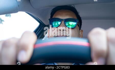 Homme conduisant dans la voiture avec des lunettes de soleil Banque D'Images