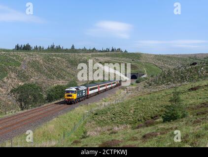 Le train « The Staycation Express » quitte le tunnel de Rise Hill Le pittoresque s'installe à Carlisle ligne de chemin de fer en classe 47 locomotive 47593 Banque D'Images