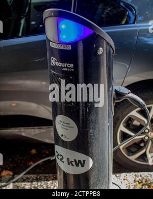 Point de recharge de voiture électrique dans la rue à South Kensington, Londres ; voiture Jaguar en cours de recharge. Banque D'Images