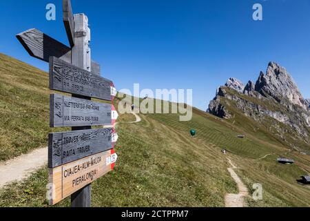 Un panneau en bois dirige les marcheurs vers un choix de sentiers dans les Dolomites au-dessus de Selva di Val Gardena, en Italie. Banque D'Images