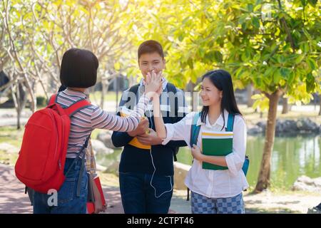 Groupe d'étudiants jeunes heureux toucher les mains en plein air, divers jeunes étudiants Livre en plein air concept Banque D'Images