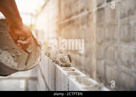 Travailleur construisant des briques de mur avec ciment local Thaïlande Banque D'Images