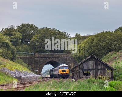 Services de locomotive classe 47 locomotive 47593 passant devant le tunnel Shotlock (Garsdale) Avec le train touristique 'Staycation Express' Banque D'Images