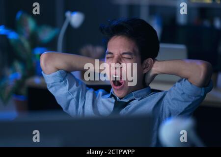 Homme d'affaires dans le bureau la nuit travaillant tard Banque D'Images