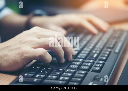 Gros plan sur la saisie des mains masculines sur le clavier. Banque D'Images