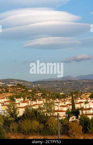 Grands nuages lenticulaires sur les toits des maisons résidentielles dans un logement au coucher du soleil Banque D'Images