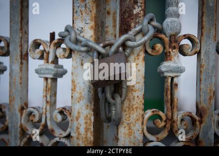 Chaîne avec cadenas sur grille en fer rouillé. Mise au point sélective Banque D'Images