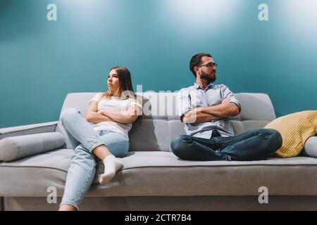 Le mari et la femme s'assoient sur le canapé après une querelle et ne parlent pas l'un à l'autre. Banque D'Images