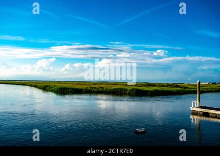Vue sur la baie luxuriante de Wildwood, New Jersey Avec un petit quai et un bouey flottant dans le Premier plan et un pont en arrière-plan Banque D'Images