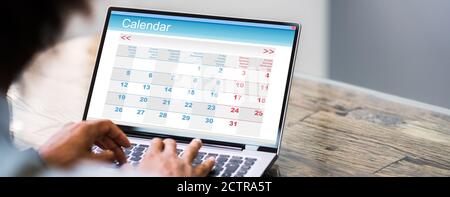 Close-up of a Businessman Looking At Calendrier avec l'ordre du jour On laptop computer Banque D'Images