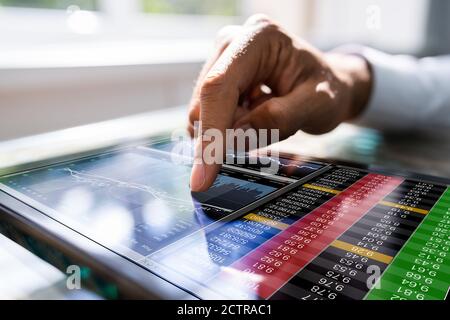 L'homme africain utilise les données du marché boursier sur une tablette Banque D'Images