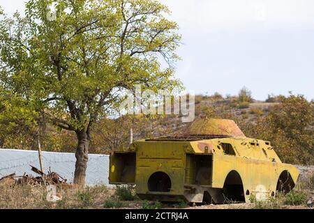 Une coquille de porte-troupes, détruite dans un conflit antérieur, est laissée sur le côté de la route dans la zone rurale du Ngarno Karabakh, un territoire contesté et combattu. Banque D'Images