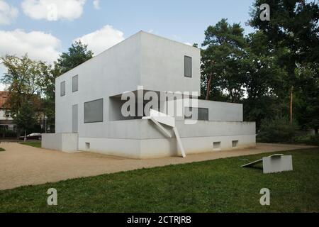 Maison Gropius (Meisterhaus Gropius) dans le domaine des maisons des nouvelles maîtres (Neue Meisterhäuser) conçu par Bruno Fioretti Marquez Architects à Dessau en Saxe-Anhalt, Allemagne. Deux maisons de maîtres originales (Meisterhäuser) conçues par l'architecte moderniste allemand Walter Gropius (1925-1926) pour les maîtres Bauhaus ont été partiellement détruites pendant la Seconde Guerre mondiale et redécorées en 2014. Walter Gropius vivait lui-même dans la maison qui était autrefois sur ce site. L'installation temporaire du sculpteur allemand Inge Mahn est vue au premier plan. Banque D'Images