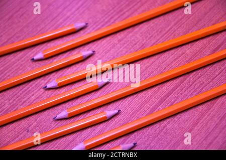 Une couche plate de plusieurs crayons orange commandés alignés avec diagonale de l'image Banque D'Images