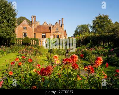 Chenies Manor House Sunken Garden sur un après-midi ensoleillé de septembre 2020. Dahlias colorés, bordures de plantes herbacées, pelouse, treillis d'ivie; ciel bleu. Banque D'Images