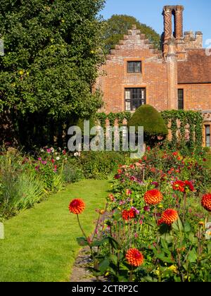 Chenies Manor House Sunken Garden sur un après-midi ensoleillé de septembre 2020. Dahlias colorés, bordures de plantes herbacées, pelouse, treillis d'ivie; ciel bleu. Banque D'Images