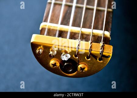 Vue rapprochée de l'extrémité du cou d'une guitare de voyage montrant les raccords, les cordes et les frets en laiton. Banque D'Images