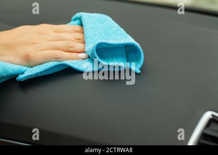 Gros plan d'une femme essuyant l'intérieur de la voiture avec un chiffon bleu Banque D'Images