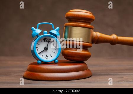 Réveil et marteau jugez le gavel sur fond marron Banque D'Images