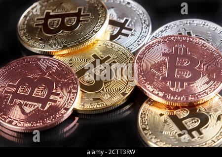Gros plan de bitcoins or, argent et cuivre sur fond noir Banque D'Images