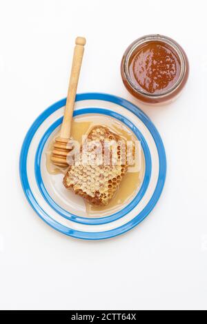 Nid d'abeille sur une plaque de cornishware avec un Drizzler Banque D'Images