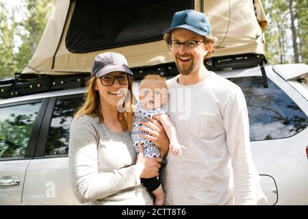 Portrait de parents avec bébé fils (6-11 mois) en camping en forêt, Wasatch cache National Forest Banque D'Images