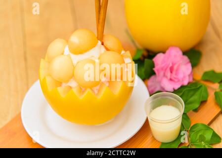 Bingsoo de melon avec du lait concentré sucré sur une table en bois Banque D'Images