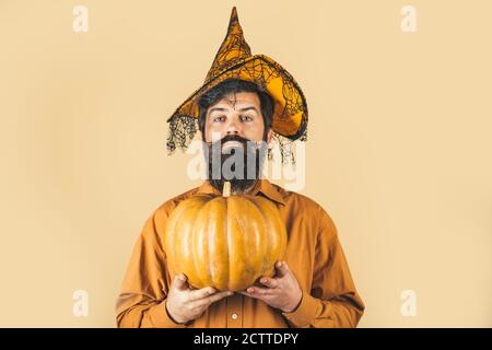 Jeune homme avec chapeau de sorcière prêt à Halloween partie. Homme d'Halloween barbu dans un chapeau de sorcière - prise de vue en gros plan en studio. La cuisine de Thanksgiving. Banque D'Images