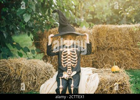 Halloween squelette enfant. Enfant gai et citrouille sur fond de soleil. Enfants amusants en costumes de carnaval. Banque D'Images