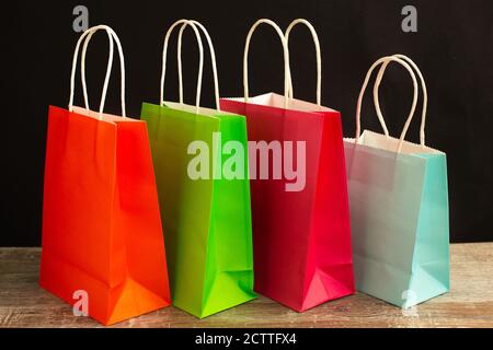 De nombreux sacs de shopping colorés autour du réveil sur fond noir. Temps de shopping Banque D'Images