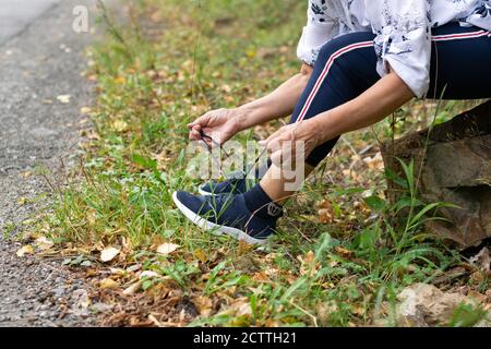 Vue écourtée d'une femme sportive âgée portant des chaussures de sport. Style de vie actif en extérieur Banque D'Images