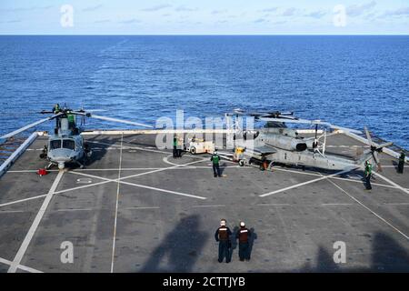 MER DES PHILIPPINES (sept 12, 2020) le personnel de la plate-forme de vol manœuvra un hélicoptère AH-1Z Cobra du Marine Medium Tiltrotor Squadron (VMM) 262 en position d'arrimage sur la plate-forme de vol du navire amphibie USS New Orleans (LPD 18). La Nouvelle-Orléans, qui fait partie du America Amphiobie Ready Group affecté au Squadron amphibie 11, ainsi que la 31e unité expéditionnaire maritime, Opère dans la zone de responsabilité de la 7e flotte des États-Unis afin d'améliorer l'interopérabilité avec les alliés et les partenaires et de servir de force d'intervention prête à l'emploi pour défendre la paix et la stabilité dans la région Indo-Pacifique. (É.-U. Marine Banque D'Images