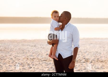 Le jeune Père embrasse et embrasse son petit fils. Portrait à l'extérieur Banque D'Images