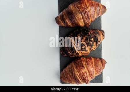 trois croissants sur un plateau noir vue sur le dessus Banque D'Images