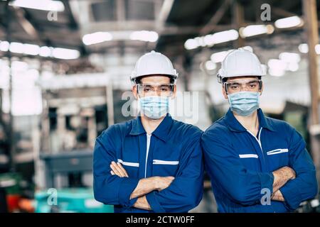 Portraitiste portant un masque facial ou un masque facial jetable pendant Équipe de service travaillant en usine pour prévenir le coronavirus (Covid-19) ou l'air pollution par la poussière Banque D'Images