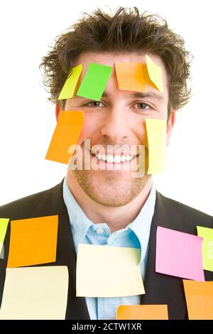 Jeune homme en costume avec beaucoup de notes adhésives dessus son visage et son corps Banque D'Images