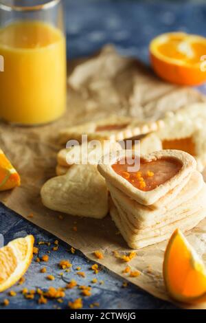 Biscuits sablés avec glaçage à l'orange en forme de coeur sur fond bleu Banque D'Images