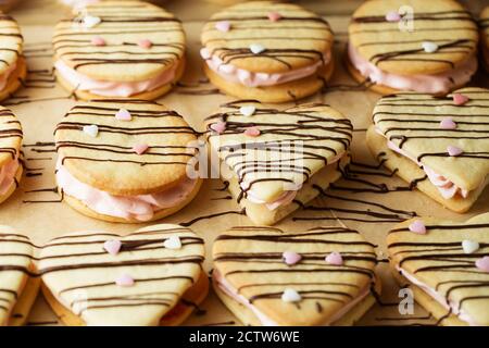 les marshmallow sont décorés de chocolat et de petits coeurs de sucre rose sur la plaque de cuisson Banque D'Images