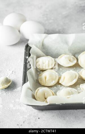 boulettes crues à la viande sur un plateau de cuisson avec de la farine Banque D'Images