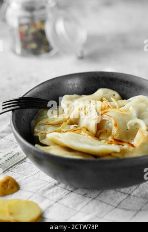 Boulettes, remplies de purée de pommes de terre et d'oignons. Plat russe, ukrainien ou polonais : varényky, vareniki, pierogi, pyrohie. Photographie alimentaire. Banque D'Images