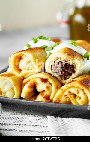 crêpes farcies savoureuses à la viande en gros plan. Crêpes fines avec garnitures. Pancakes farcis frits de Russie avec viande et giblets, coeur, lu Banque D'Images