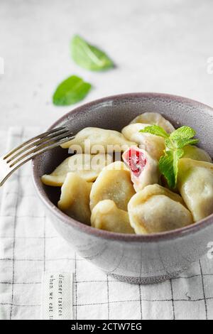 Boulettes de cerise à la menthe. Boulettes maison sucrées avec baies dans le bol sur fond gris. Délicieux boulettes de cerises. Nourriture photogra Banque D'Images