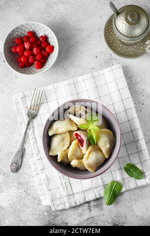 Boulettes de cerise à la menthe. Boulettes maison sucrées avec baies dans le bol sur fond gris. Délicieux boulettes de cerises. Nourriture photogra Banque D'Images