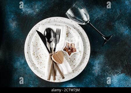 Décor de table festif. Vaisselle et couverts sur un fond texturé foncé avec espace de copie. Noël Noël nouvel an arrière-plan de vacances Banque D'Images