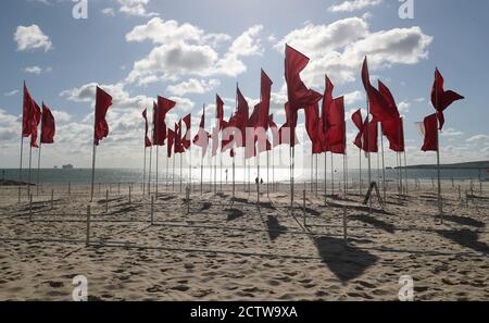 Un morceau d'œuvre de l'artiste Luke Jerram appelé 'in Memoriam', est installé sur la plage de Sandbanks dans le cadre du Bournemouth Arts par le Festival de la mer 2020. Créée à partir de plus de 100 draps et disposée sous forme de croix rouge médicale, la mer des drapeaux offre au public un endroit à visiter pour se souvenir des personnes perdues pendant la pandémie du coronavirus et rendre hommage au personnel et aux bénévoles du NHS. Banque D'Images