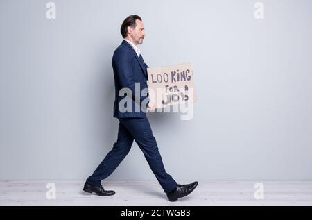 Pleine photo de profil de pleine longueur de personne sans emploi licencié âgé mature gars homme crise financière accident perdu travail porter carton travail étiquette entrepreneur du marché Banque D'Images
