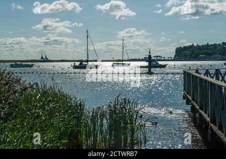 Baie de Cardiff, vue sur le canal de Bristol avec des bateaux amarrés comme silhouettes contre le soleil. Banque D'Images