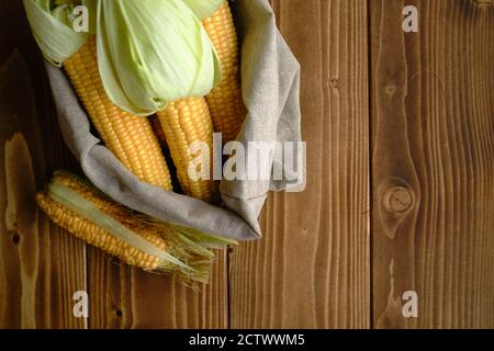 Vue de dessus de la vue de cornobs frais ouverts avec des huttes dedans un sac avec un fond de surface en bois Banque D'Images