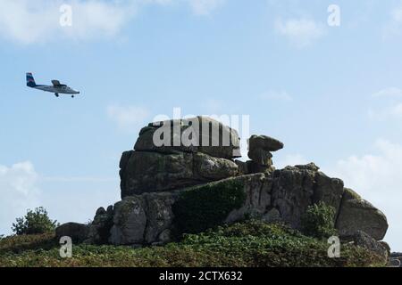 Un avion de Skybus survolant Camel Rock chargé à Porth Hellick, St Mary's, Isles of Scilly Banque D'Images